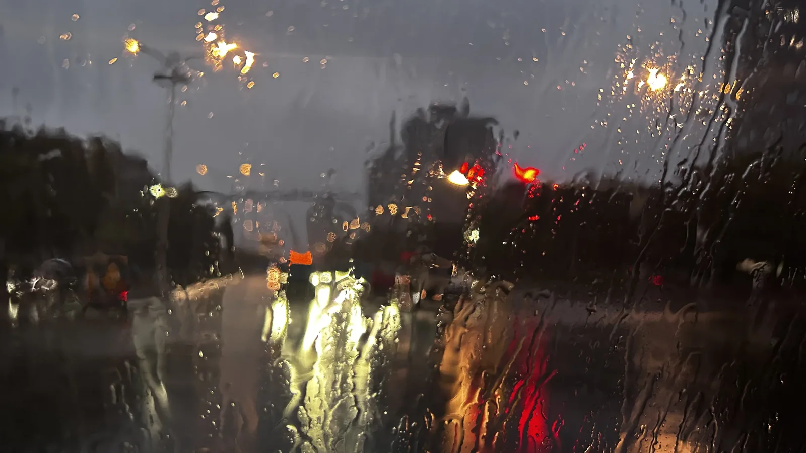 雨夜，打湿的车窗外是路灯和车尾灯